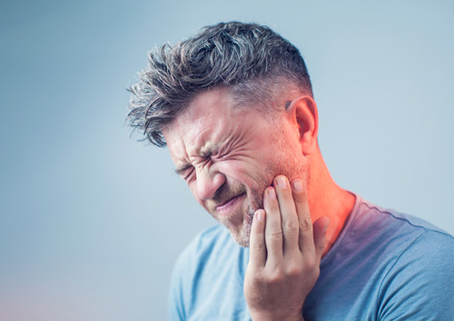 young man suffering from tooth pain
