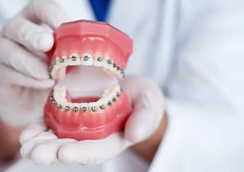 A dental specialist showing a patient the alignment results of their braces and aligners at Legacy Oral Surgery in New York and New Jersey.