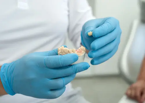 Doctor showing a 3D dental model of a jaw to a patient for a clear treatment overview at Legacy Oral Surgery in NY and NJ.